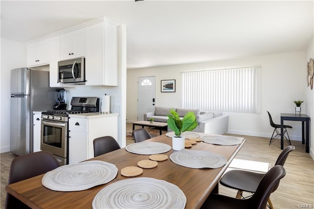 dining room with baseboards and light wood finished floors