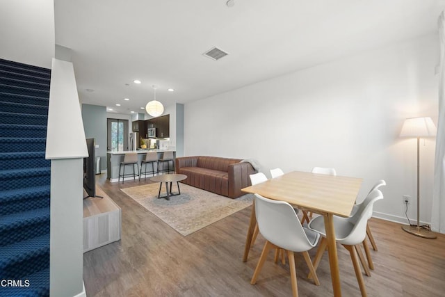 dining area featuring light wood-type flooring, stairs, visible vents, and recessed lighting