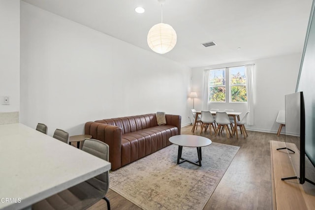 living area featuring baseboards, wood finished floors, visible vents, and recessed lighting