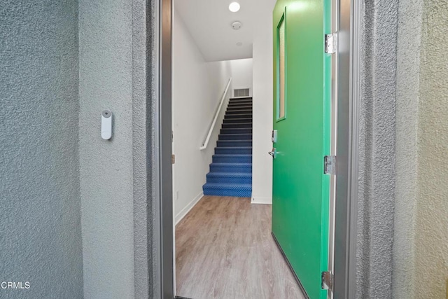 interior space featuring baseboards, stairway, and light wood-style floors