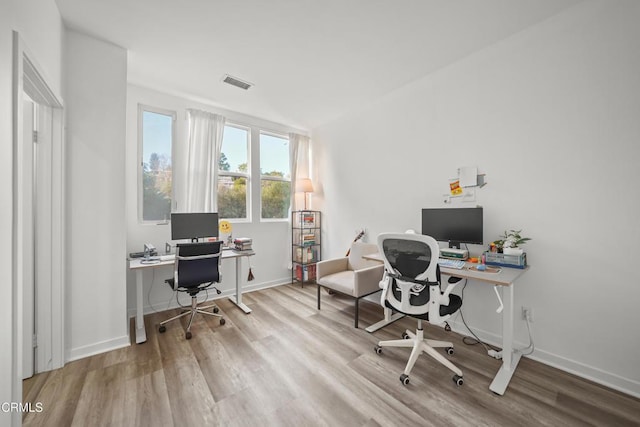 office featuring visible vents, light wood-style flooring, and baseboards