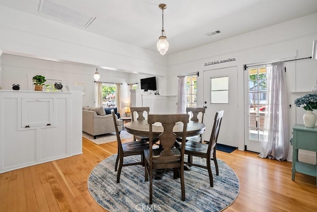 dining space featuring light wood-type flooring and visible vents