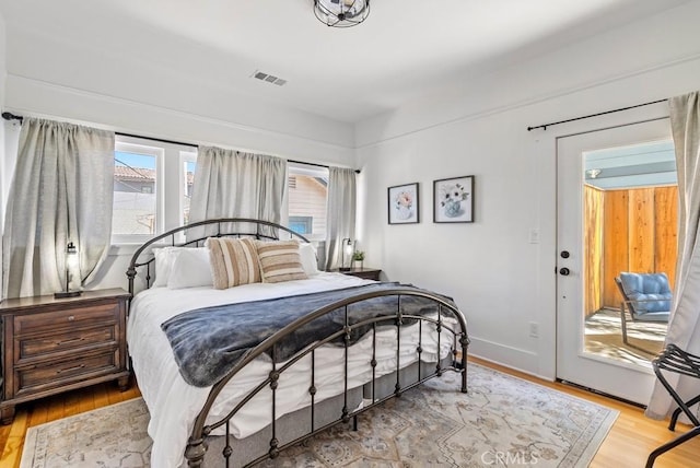 bedroom featuring light wood finished floors, baseboards, and visible vents