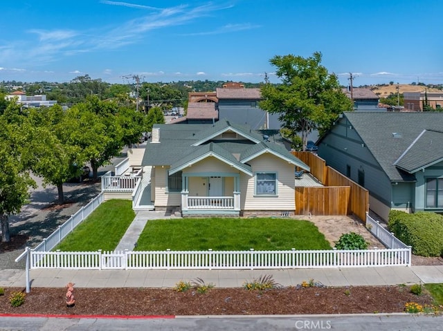 view of front of property featuring a fenced front yard, a residential view, a porch, and a front yard