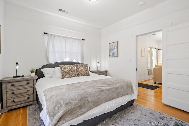 bedroom featuring visible vents and wood finished floors