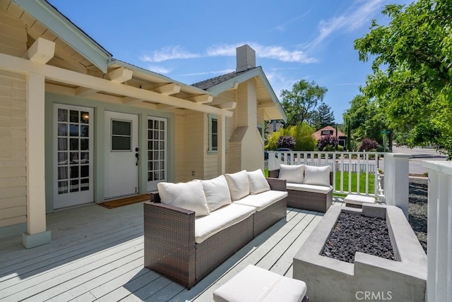 wooden terrace featuring an outdoor living space with a fire pit