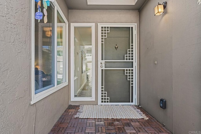 entrance to property featuring stucco siding