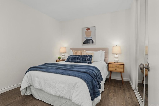 bedroom featuring baseboards and dark wood-style flooring