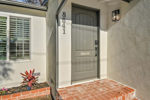 property entrance with stucco siding