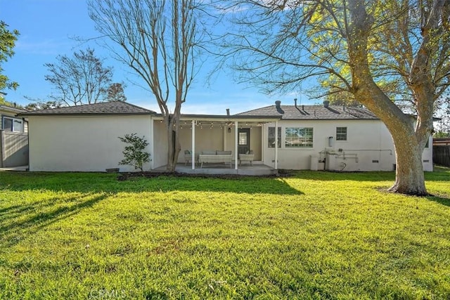 back of house featuring a yard, a patio area, and stucco siding