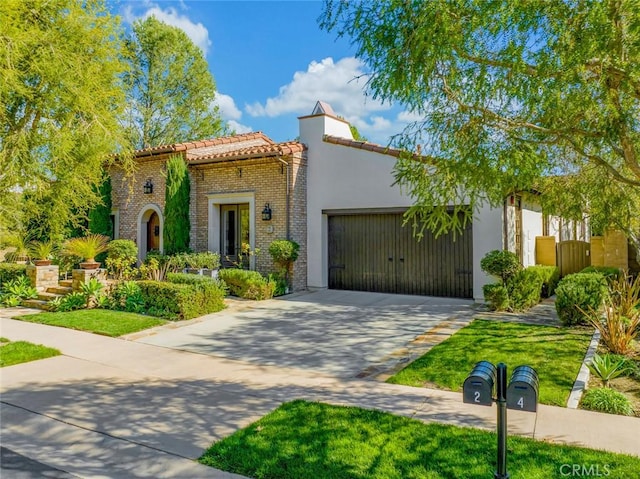 mediterranean / spanish home featuring an attached garage, a tile roof, concrete driveway, and brick siding