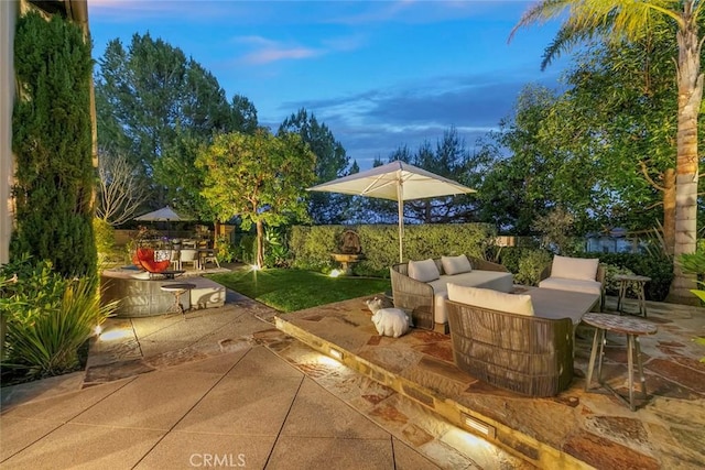 patio terrace at dusk featuring an outdoor living space