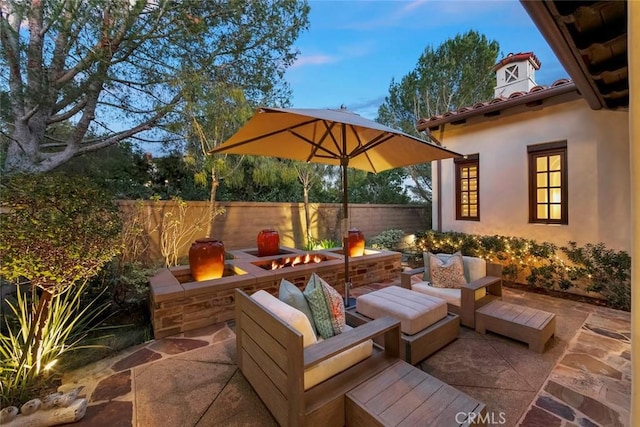 view of patio / terrace featuring an outdoor living space with a fire pit and fence