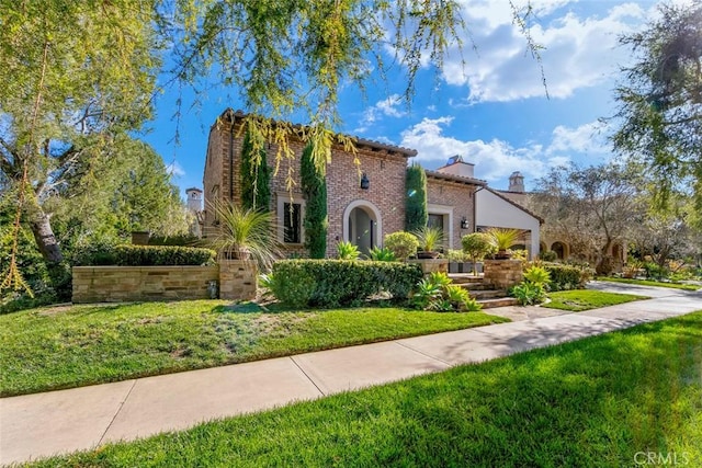 view of front of home featuring brick siding and a front yard