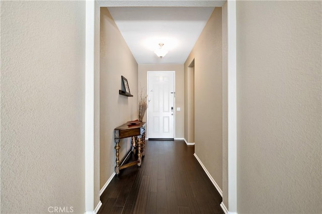 doorway to outside with dark wood-style floors and baseboards