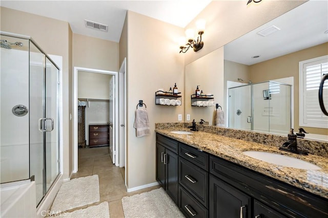 bathroom featuring a stall shower, tile patterned flooring, visible vents, and a sink