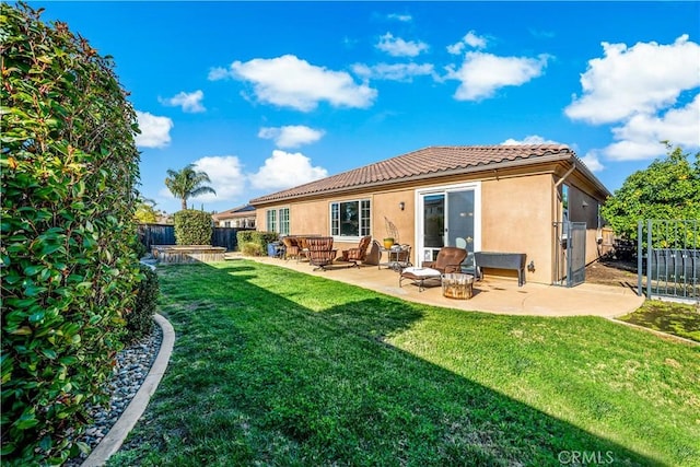 rear view of house featuring a yard, stucco siding, a patio area, a fenced backyard, and a tiled roof