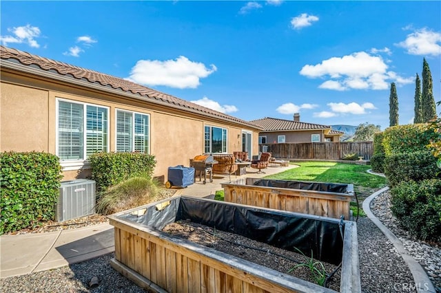 rear view of property with central air condition unit, fence, a tiled roof, stucco siding, and a patio area