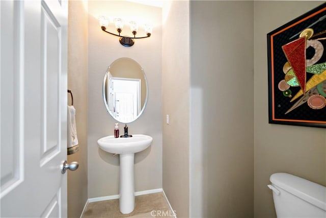 bathroom with tile patterned floors, toilet, and baseboards