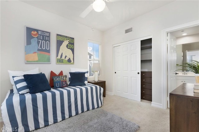 carpeted bedroom featuring connected bathroom, a ceiling fan, visible vents, baseboards, and a closet