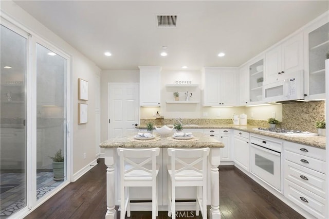 kitchen featuring dark wood-style floors, open shelves, visible vents, white cabinetry, and white appliances