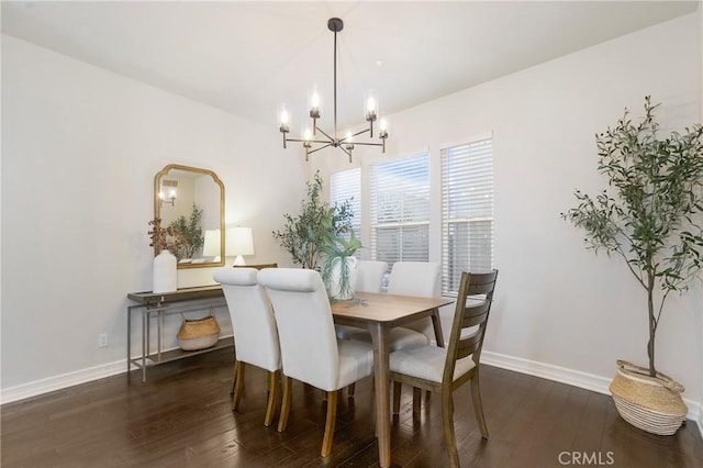 dining space featuring an inviting chandelier, baseboards, and wood finished floors