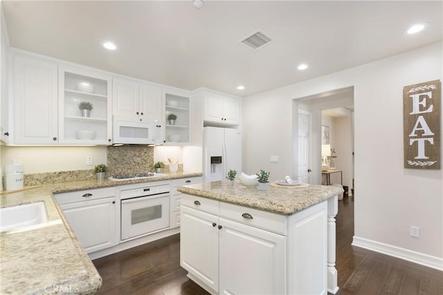 kitchen with white appliances, glass insert cabinets, dark wood-style flooring, and recessed lighting