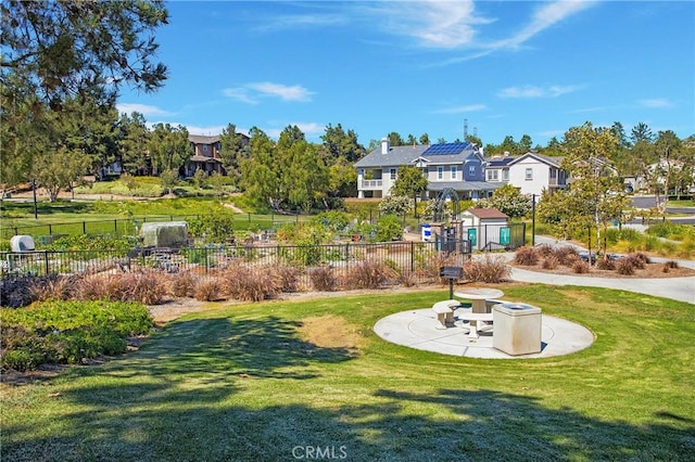 view of community with a yard, fence, and a patio