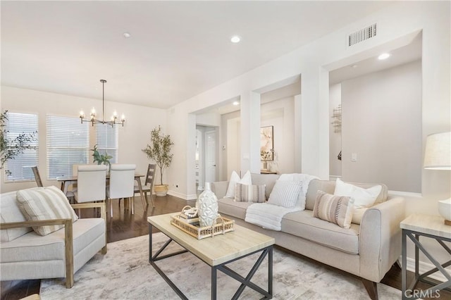 living area with visible vents, baseboards, light wood-style flooring, a chandelier, and recessed lighting