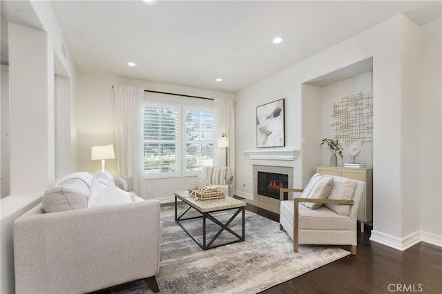 living area featuring visible vents, baseboards, a tiled fireplace, dark wood-type flooring, and recessed lighting