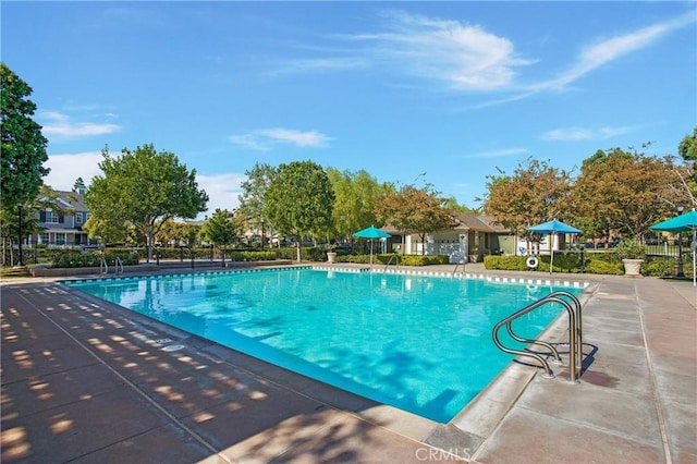 pool with a patio and fence