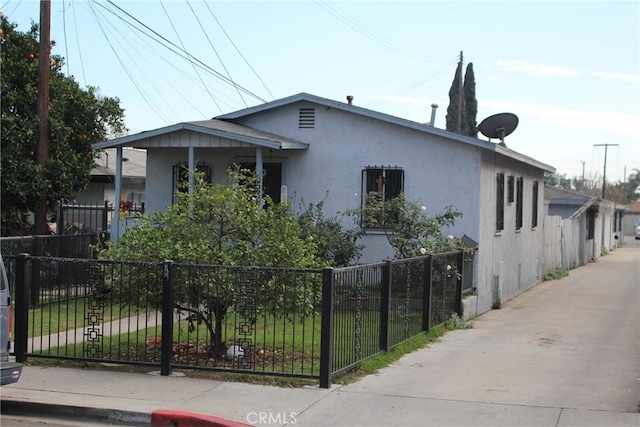 view of property exterior featuring a fenced front yard and stucco siding