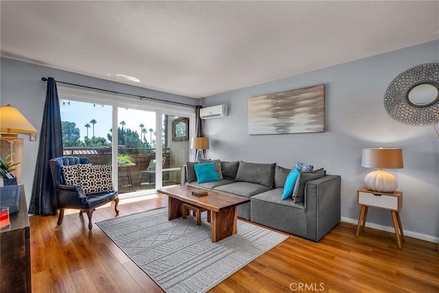 living room featuring a wall unit AC, baseboards, and wood finished floors