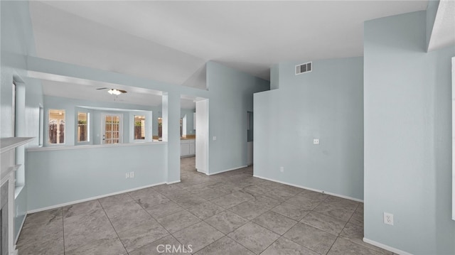 empty room featuring a fireplace, visible vents, and baseboards