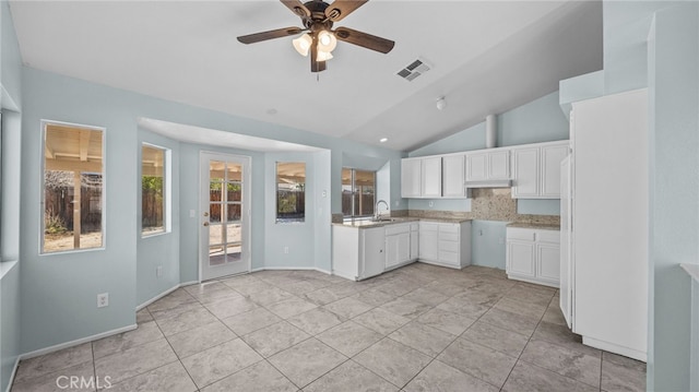 kitchen featuring lofted ceiling, a sink, visible vents, white cabinets, and light countertops