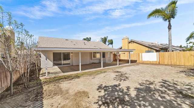 rear view of house with a patio, a fenced backyard, and stucco siding