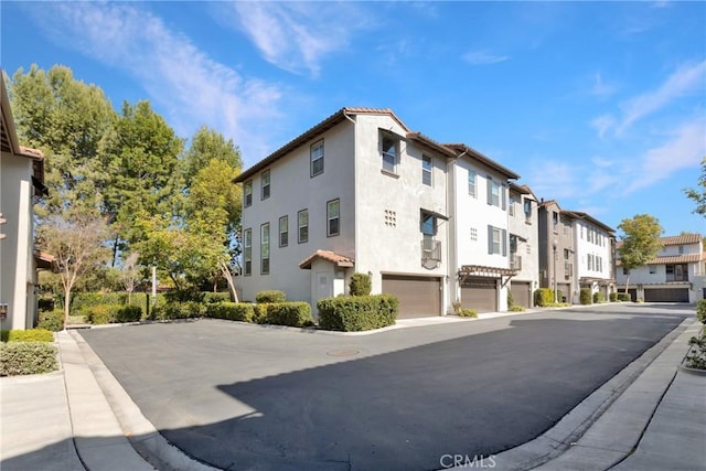 view of building exterior with an attached garage and a residential view