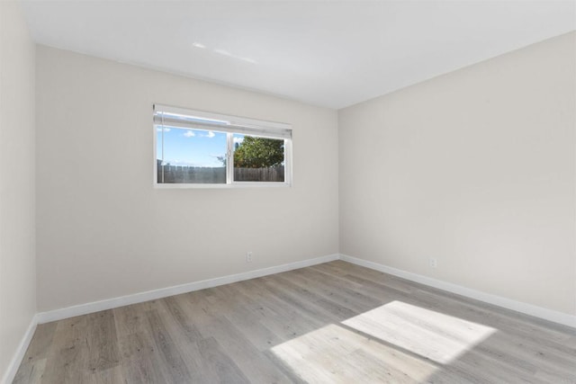 empty room with light wood finished floors and baseboards