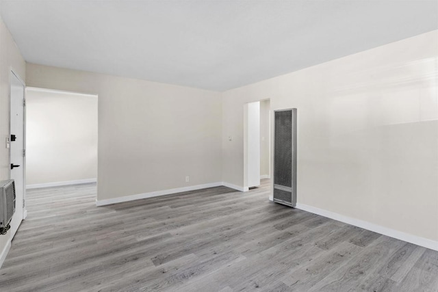 spare room featuring light wood-style floors and baseboards