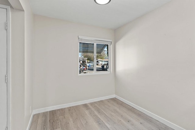 spare room featuring light wood finished floors and baseboards