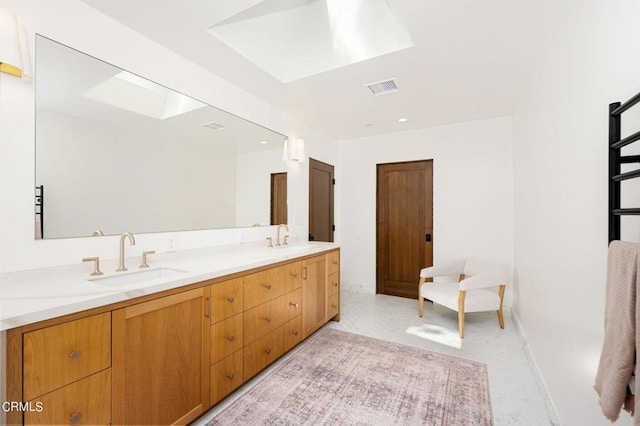 full bath with a skylight, visible vents, and a sink