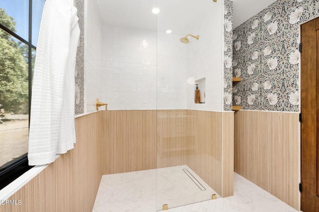 bathroom featuring wainscoting, tile walls, and walk in shower