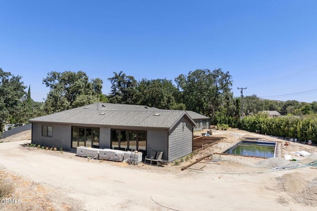 back of house featuring a shingled roof