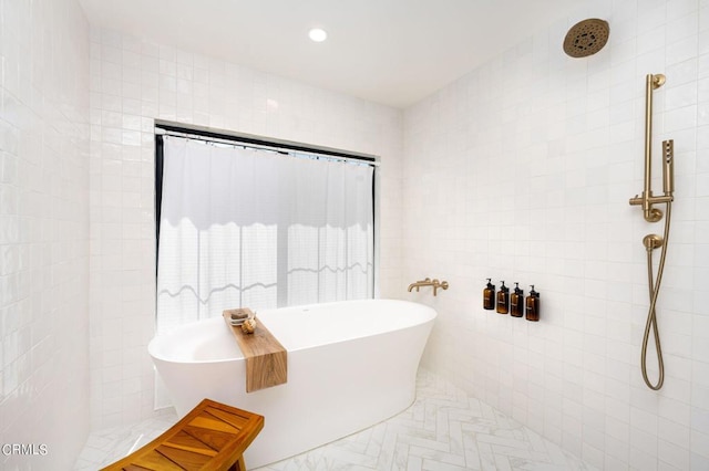 full bath with a freestanding bath, tiled shower, tile walls, and recessed lighting