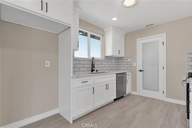 kitchen featuring visible vents, backsplash, white cabinetry, a sink, and dishwasher