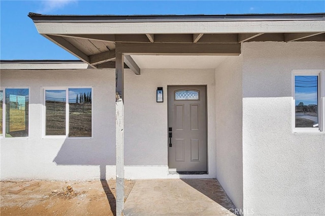 doorway to property featuring stucco siding