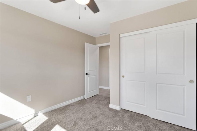 unfurnished bedroom with visible vents, baseboards, a ceiling fan, light colored carpet, and a closet