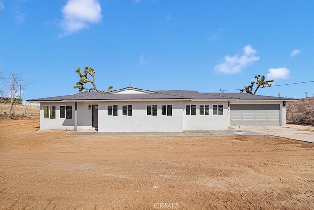 single story home featuring a garage, driveway, and stucco siding