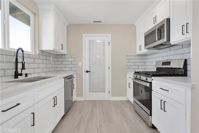 kitchen featuring white cabinetry, appliances with stainless steel finishes, and a sink