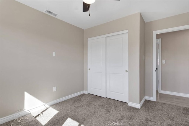 unfurnished bedroom featuring baseboards, visible vents, light colored carpet, ceiling fan, and a closet